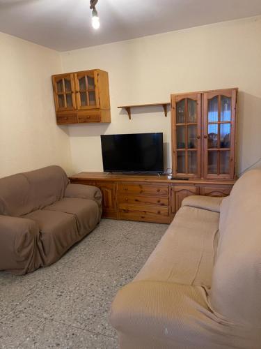 a living room with two couches and a flat screen tv at Mas del Llorenç in Ulldemolins