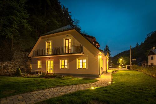 a white house with a balcony at night at Apartmány Weissov Dom in Banská Štiavnica
