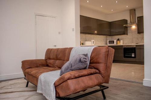 un divano marrone con una coperta in soggiorno di Charming Central Room ad Aintree