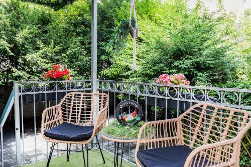 three chairs and a table on a balcony with flowers at Hotel Fürst Garden in Dortmund