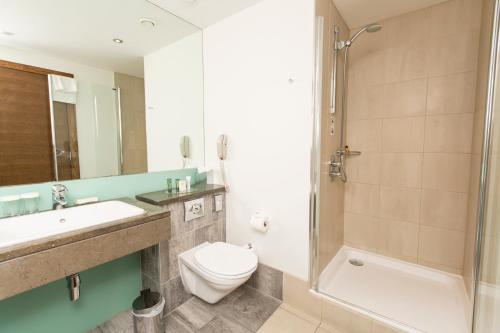 a bathroom with a toilet and a sink and a shower at Hilton London Canary Wharf in London