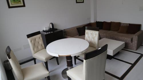 a living room with a white table and chairs at VENUS.HOTEL in Mohali