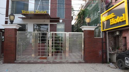 a brick building with a gate in front of a store at VENUS.HOTEL in Mohali