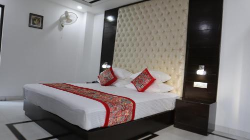 a bedroom with a large bed with red pillows at VENUS.HOTEL in Mohali