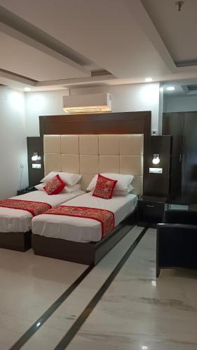 a bedroom with two beds with red pillows at VENUS.HOTEL in Mohali