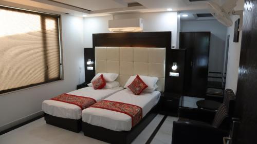 a bedroom with a large bed with red pillows at VENUS.HOTEL in Mohali