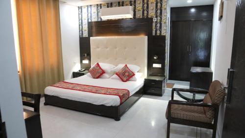 a hotel room with a bed and a chair at VENUS.HOTEL in Mohali