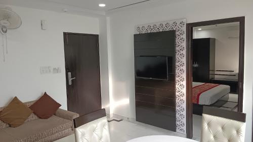 a living room with a couch and a tv and a mirror at VENUS.HOTEL in Mohali
