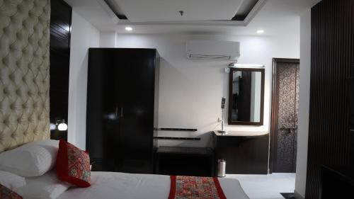 a hotel room with a bed and a mirror at VENUS.HOTEL in Mohali