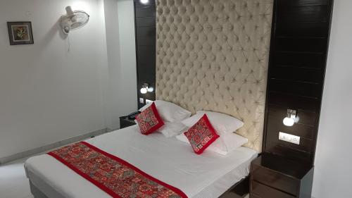 a bedroom with a bed with two red pillows at VENUS.HOTEL in Mohali