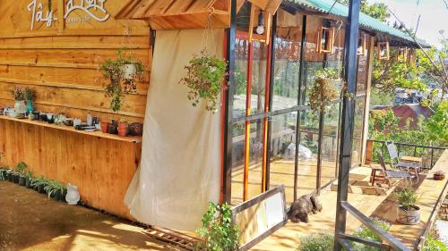 a wooden building with a patio with potted plants at Dốc Nhà Tây in Da Lat