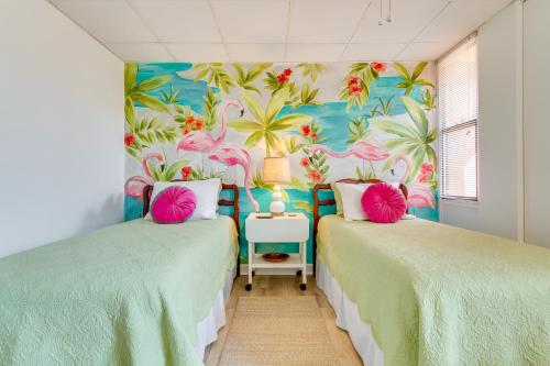 2 camas en una habitación con un mural de flamencos en Gulf Breeze Escape with Patio and Community Pool!, en Gulf Breeze