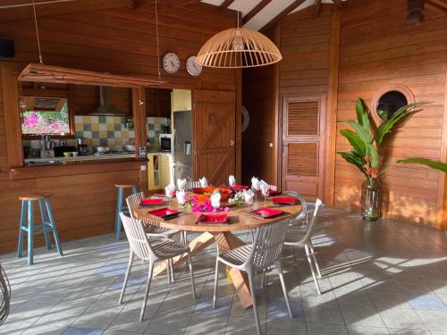 a kitchen and dining room with a table and chairs at Villa Nature caraïbe lodge, vue mer, piscine privée in Deshaies