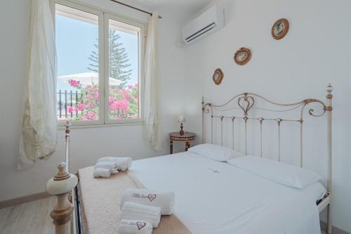 een slaapkamer met een wit bed met handdoeken erop bij Appartamento con vista piscina in Noto