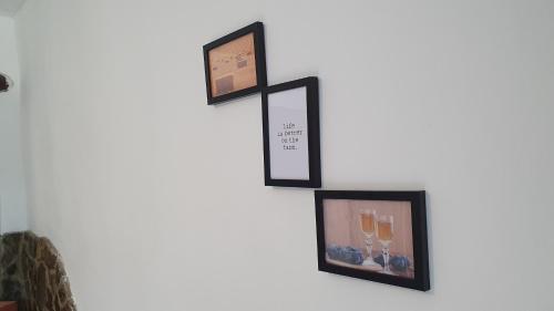 a group of three framed pictures on a wall at Cazare la fermă in Galeşu