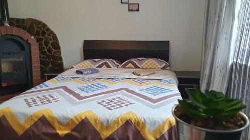 a bedroom with a bed with a quilt on it at Cazare la fermă in Galeşu