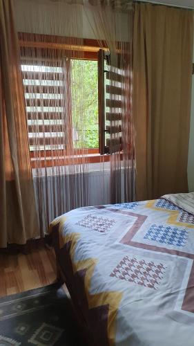 a bedroom with a bed in front of a window at Cazare la fermă in Galeşu