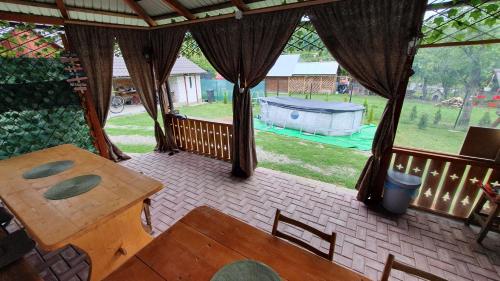 a screened porch with a table and a view of a yard at Cazare la fermă in Galeşu