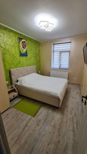 een slaapkamer met een bed en een groene muur bij Apartament ultra central! in Iaşi