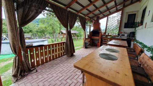 a large room with a wooden table on a patio at Cazare la fermă in Galeşu