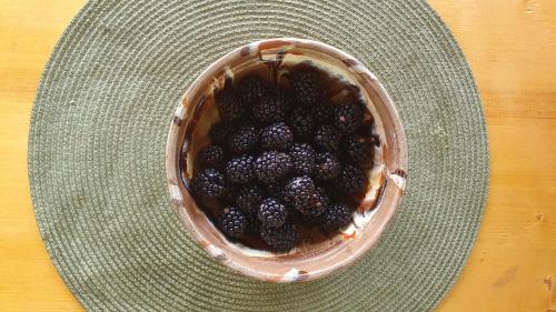 a basket filled with blackberries on a wooden table at Cazare la fermă in Galeşu