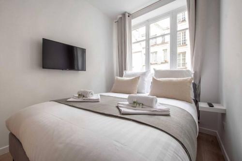 une chambre avec un grand lit blanc avec des serviettes dessus dans l'établissement Sentier Historical Center II Luxury Design Apartment 3BR-8P, à Paris