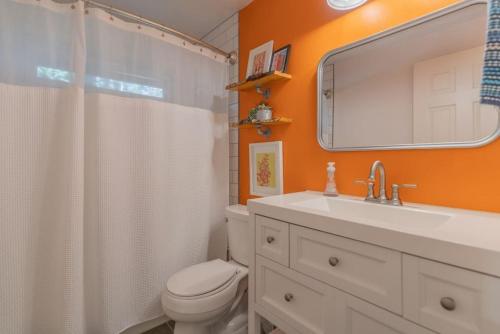 uma casa de banho com um WC, um lavatório e um espelho. em The Upper Fairbanks Street Retreat 1 em Fairbanks