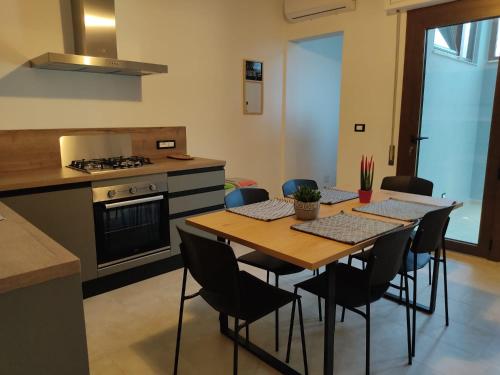 a kitchen with a table and chairs and a stove at La Stazione in Monserrato