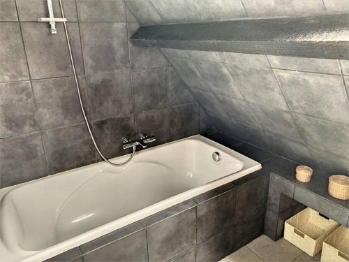 a bathroom with a white bath tub in a room at Le Odette - Campagne chic in Jaux