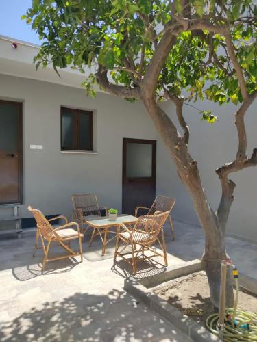 un patio con tavolo e sedie sotto un albero di La Stazione a Monserrato
