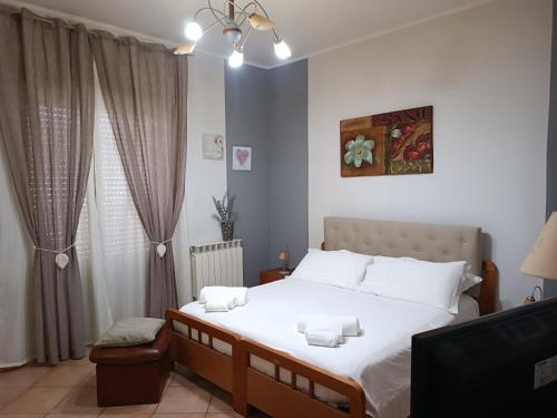 een slaapkamer met een groot wit bed en een raam bij Il Melograno in Gaggi