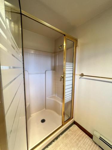 a shower with a glass door in a bathroom at The Peregrine Suite - Comfort and Luxury in the Heart of Kodiak in Kodiak