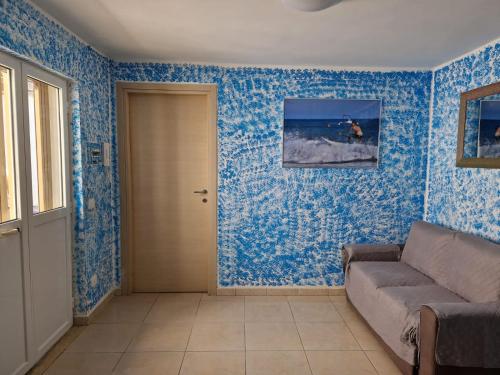 sala de estar con paredes azules y sofá en PICCOLA RAFFICA, en Fregene