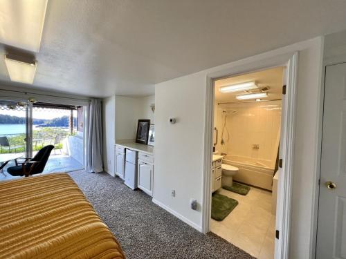 1 dormitorio con 1 cama y baño con ducha en The Captains View - Cliffside, Ocean Views en Kodiak