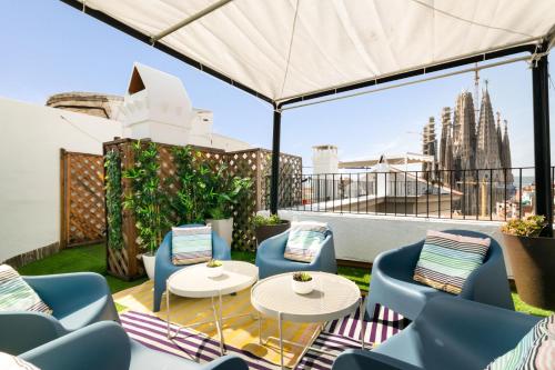 een patio met stoelen en tafels en uitzicht op de stad bij Suite Home Sagrada Familia in Barcelona