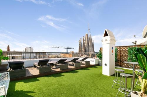 a rooftop patio with grass and chairs on a roof at Suite Home Sagrada Familia in Barcelona