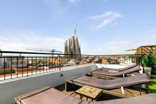 uma varanda com espreguiçadeiras e vista para a cidade em Suite Home Sagrada Familia em Barcelona