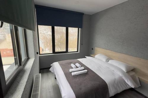 a bedroom with a large bed with towels on it at Twins in Tbilisi City