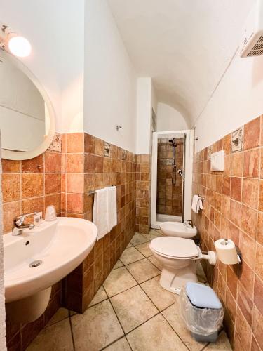 a bathroom with a sink and a toilet at S’ammentu house in Bosa