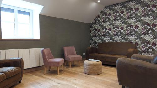 a living room with a couch and chairs and a window at L'orcheran in Vielverge