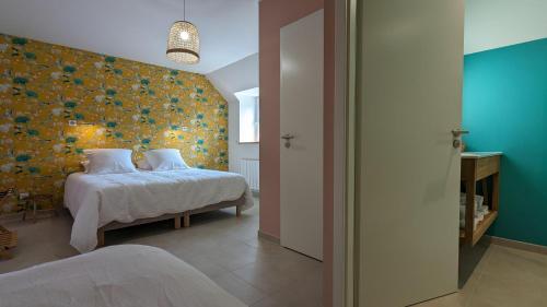 - une chambre avec un lit et un mur fleuri dans l'établissement L'orcheran, à Vielverge