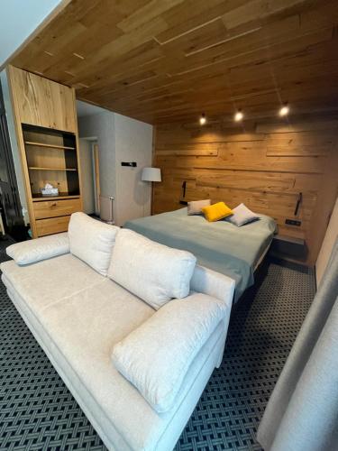 a hotel room with two beds and a couch at Rezidence Alpina in Špindlerův Mlýn