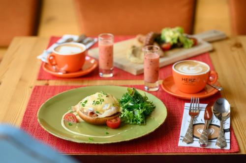 a table with a plate of food and two cups of coffee at Maison Bistro & Hotel in Budapest