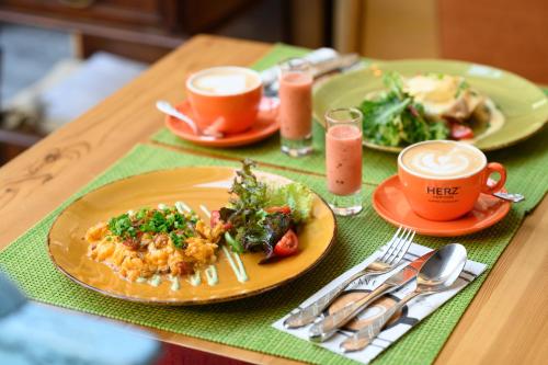 a table with plates of food and cups of coffee at Maison Bistro & Hotel in Budapest