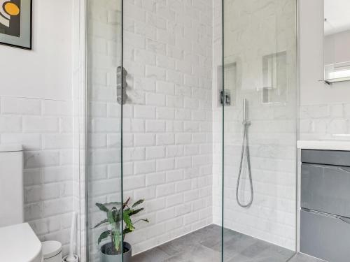 a shower with a glass door in a bathroom at Pass the Keys Stunning 3BR House with Garden Oasis in London