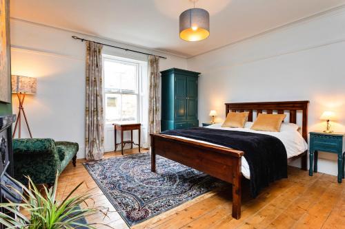 um quarto com uma cama, um sofá e uma cadeira em Finest Retreats - Upper Howick House em Alnwick