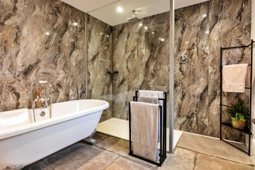 La salle de bains est pourvue d'une baignoire, d'un lavabo et d'une douche. dans l'établissement Finest Retreats - Upper Howick House, à Alnwick