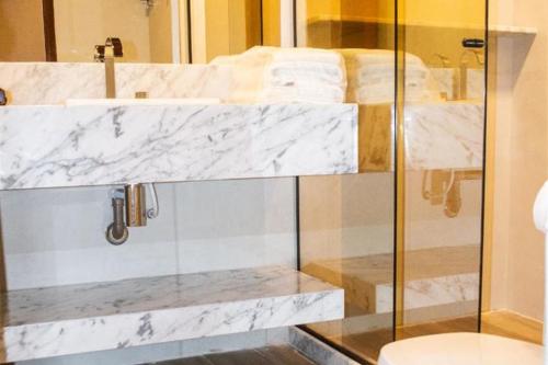 a bathroom with a glass shower with a toilet at Serrambi Resort in Porto De Galinhas