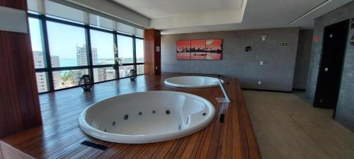 a large bathroom with a large tub on a wooden floor at Std Time Maceió in Maceió