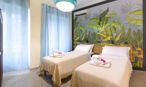 two beds in a room with a mural at PeoniaMaximaHouse -Piazza Bologna- in Rome